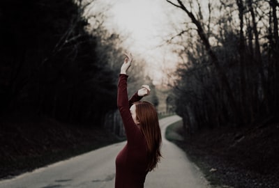 被拦腰的道路中间的女举手选择性聚焦摄影